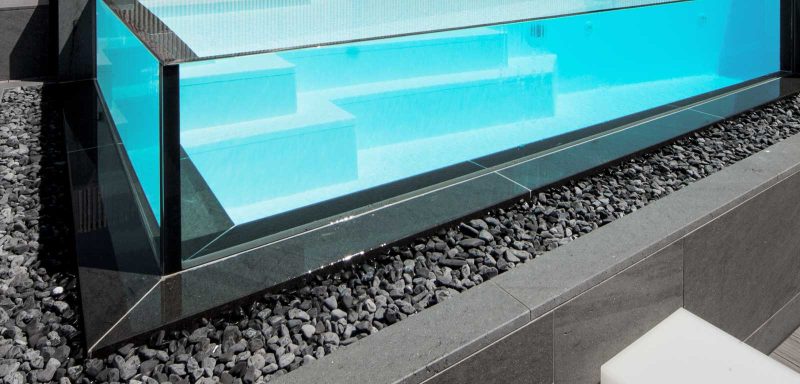 piscina con lati a cascata che fanno scorrere l'acqua sul canale con ciottoli