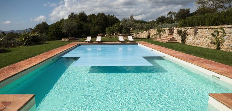 piscina rettangolare a sfioro, scala recessa e con copertura a tapparella