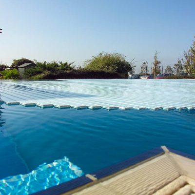 piscina a sfioro con copertura a tapparella