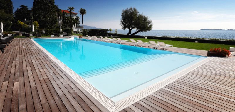 piscina vista lago con scalinata, luci, bordo sfioro, solarium piscina in legno