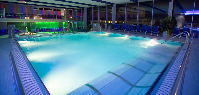 piscina con panche idromassaggio e illuminazione subacquea