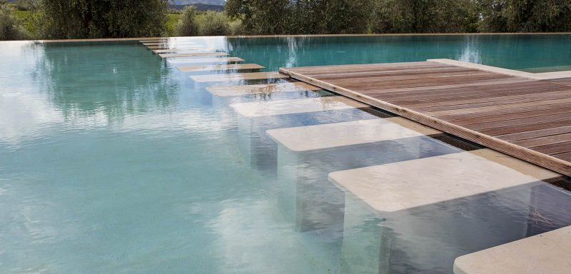 due piscine con zona di connessione e sfioro nascosto al di sotto della pavimentazione