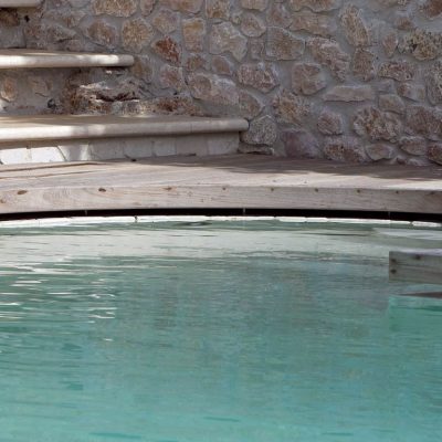 particolare di un'area relax in piscina con sfioro nascosto al di sotto del pavimento