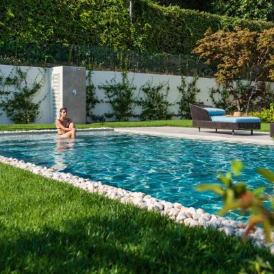 Piscina con finitura esterna in gres e sassi di fiume