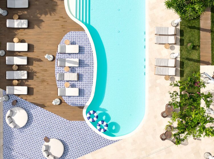 Zona piscina arredata con mobili e piante