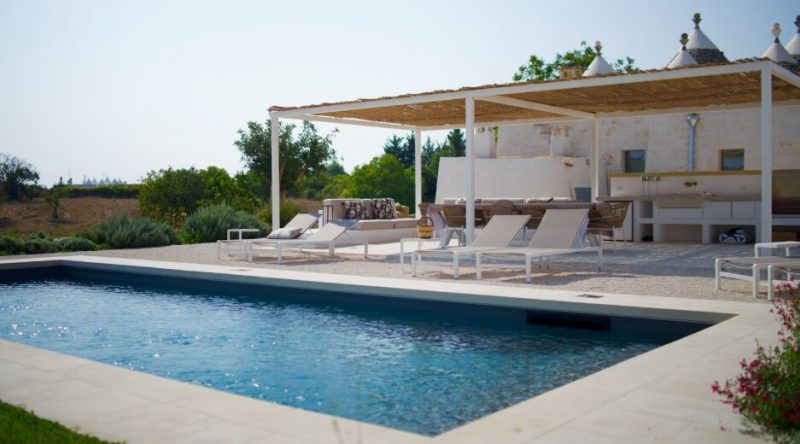 Una piscina esterna con portico